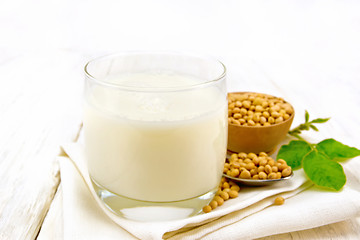 Image showing Milk soy in glass with leaf on board