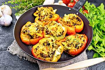 Image showing Pepper stuffed with mushrooms and couscous in old pan on burlap