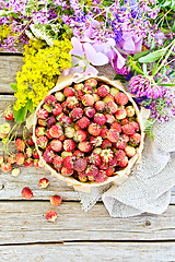 Image showing Strawberries in box with flowers on board top