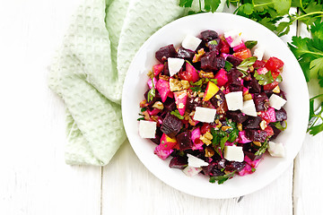 Image showing Salad with beetroot and feta in plate on board top