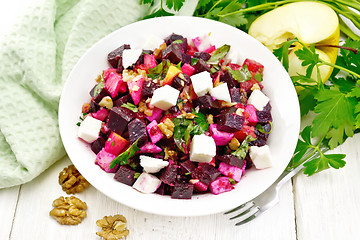 Image showing Salad with beetroot and walnuts in plate on board