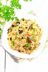 Image showing Risotto with mushrooms and chicken on wooden board top