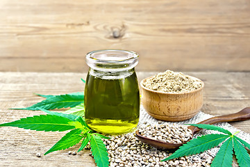 Image showing Oil hemp in jar with flour in bowl on wooden board