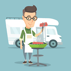 Image showing Man having barbecue in front of camper van.