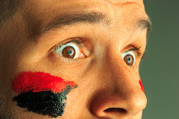 Image showing Portrait of a man with the flag of the Germany painted on him face.