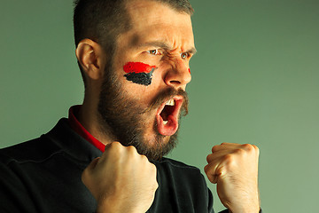 Image showing Portrait of a man with the flag of the Germany painted on him face.