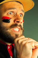 Image showing Portrait of a man with the flag of the Germany painted on him face.