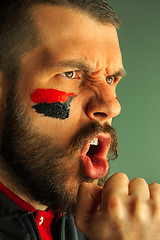 Image showing Portrait of a man with the flag of the Germany painted on him face.