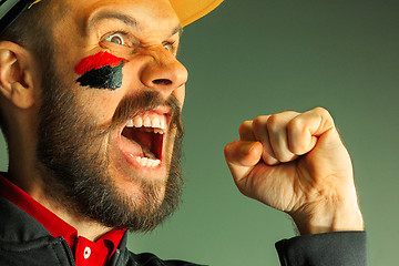 Image showing Portrait of a man with the flag of the Germany painted on him face.