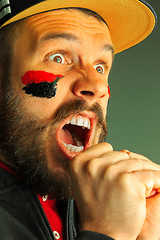 Image showing Portrait of a man with the flag of the Germany painted on him face.