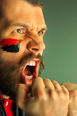 Image showing Portrait of a man with the flag of the Germany painted on him face.