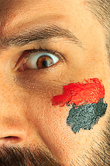 Image showing Portrait of a man with the flag of the Germany painted on him face.