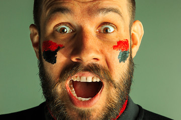 Image showing Portrait of a man with the flag of the Germany painted on him face.