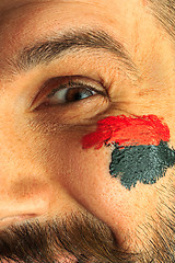 Image showing Portrait of a man with the flag of the Germany painted on him face.