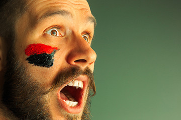 Image showing Portrait of a man with the flag of the Germany painted on him face.