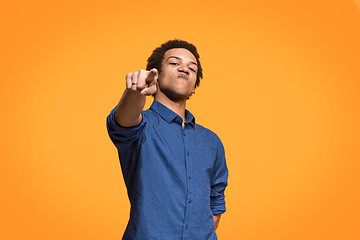 Image showing The overbearing businessman point you and want you, half length closeup portrait on orange background.