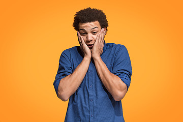 Image showing Handsome man looking suprised isolated on orange