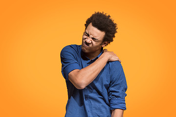 Image showing Young man overwhelmed with a pain in the shoulder.