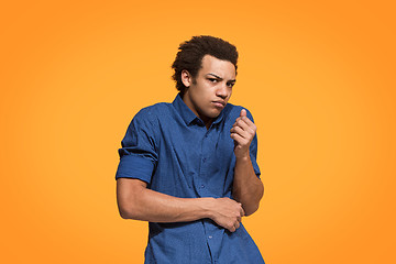 Image showing Let me think. Doubtful pensive man with thoughtful expression making choice against orange background