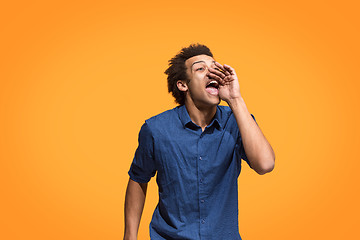 Image showing Isolated on blue young casual man shouting at studio