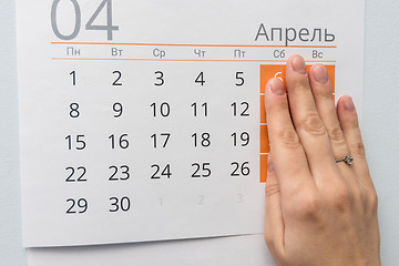 Image showing Hand closed the weekend on a sheet of calendar