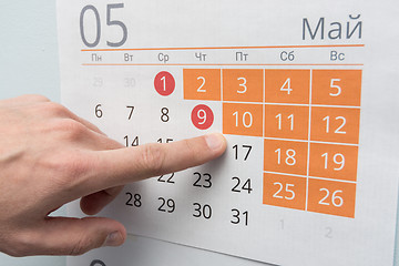 Image showing Finger points to a long holiday weekend on the wall calendar