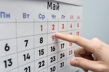 Image showing Hand points to the May 2 holiday on a wall calendar sheet