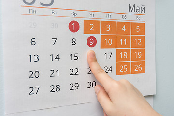 Image showing Children\'s hand points to the long May holidays holiday in the wall calendar
