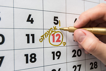 Image showing Hand marker on the wall calendar marks the date of the holiday