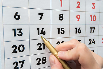 Image showing Hand marker indicates the date on the wall calendar