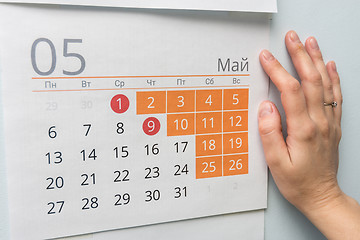 Image showing Hand next to the wall calendar