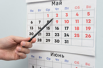 Image showing Pencil hand indicates long weekends and holidays on a wall calendar