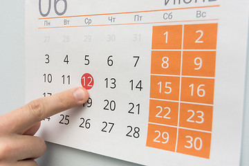 Image showing Finger points to a holiday in the wall calendar
