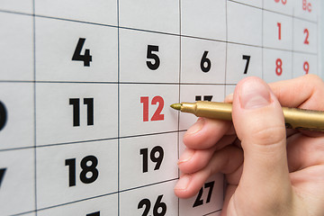 Image showing Hand marker indicates the 12th number in the wall calendar