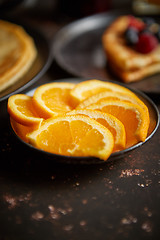 Image showing Close up on fresh orange slices placed on ceramic saucer