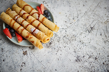 Image showing Plate of delicious crepes roll with fresh fruits and chocolate