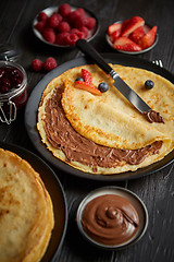 Image showing Delicious chocolate homemade pancakes on black ceramic plate