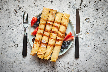Image showing Plate of delicious crepes roll with fresh fruits and chocolate