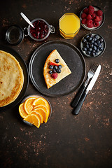 Image showing Tasety homemade pancake on black ceramic plate.