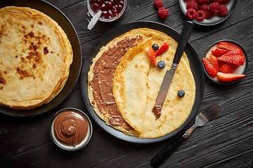 Image showing Delicious chocolate homemade pancakes on black ceramic plate