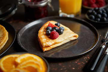 Image showing Tasety homemade pancake on black ceramic plate.