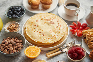 Image showing Breakfast table setting with fresh fruits, pancakes, coffee, croissants