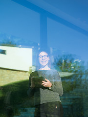 Image showing Woman using tablet at home by the window