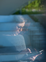 Image showing Woman using tablet at home by the window