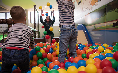 Image showing Young mom with her kids in a children\'s playroom