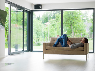 Image showing man on sofa using tablet computer