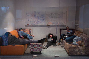 Image showing software developers sleeping on sofa in creative startup office