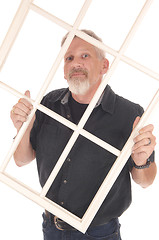 Image showing Middle age man holding window frame