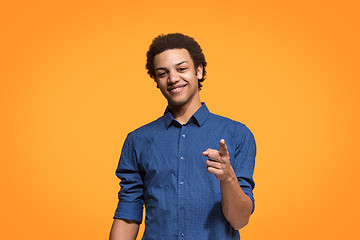 Image showing The happy business man point you and want you, half length closeup portrait on orange background.