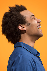 Image showing The happy business man standing and smiling against orange background.